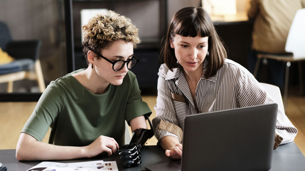 Two colleagues working on laptop in team